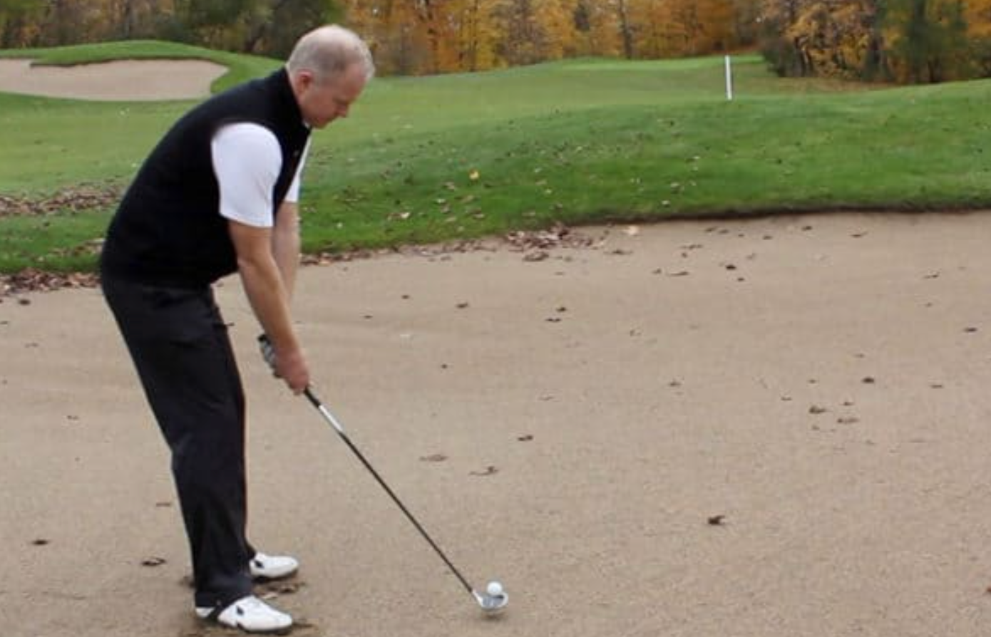 A golfer lining up a shot from a bunker